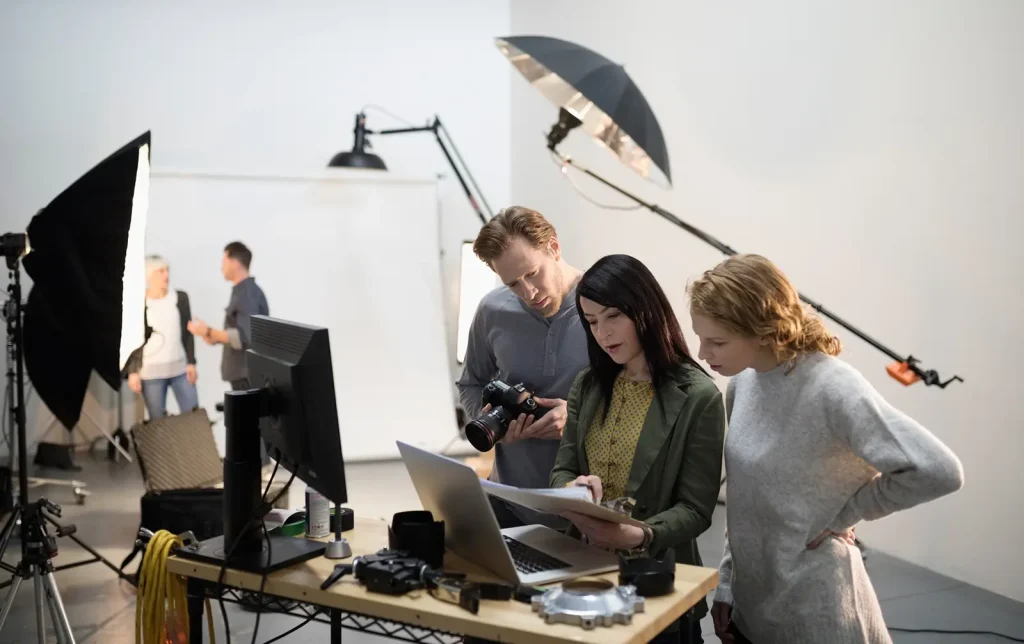 Creative team organising a photoshoot with lighting setup and styling preparation in a studio