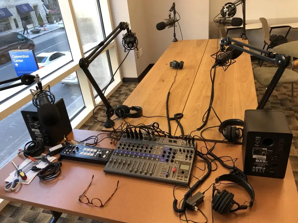 Essential equipment needed to start a podcast, including microphone, boom arm, and recording software