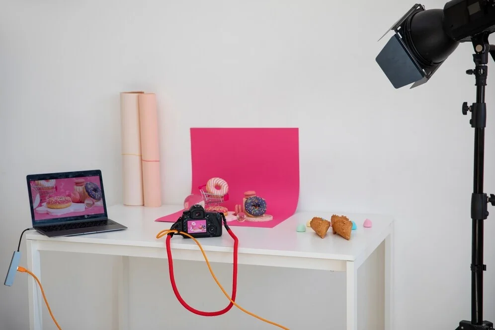 Basic product photography setup showing a smartphone, tripod, and white background in a home studio.
